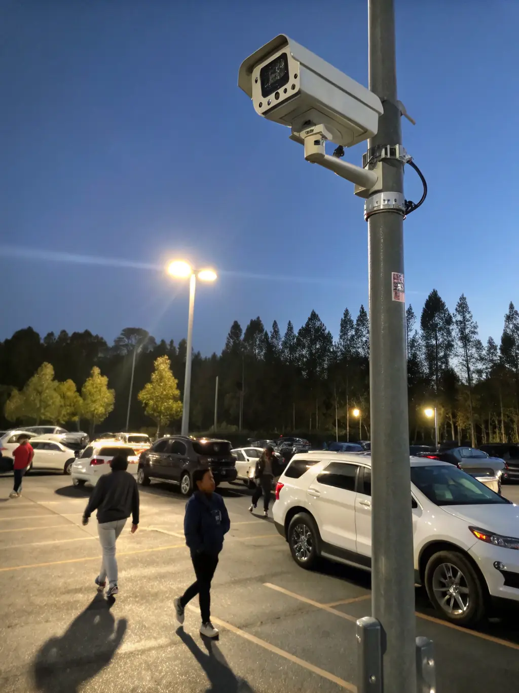 A UniFi Protect G4 Pro camera capturing a parking lot scene at night, demonstrating its excellent low-light performance and ability to capture clear details.