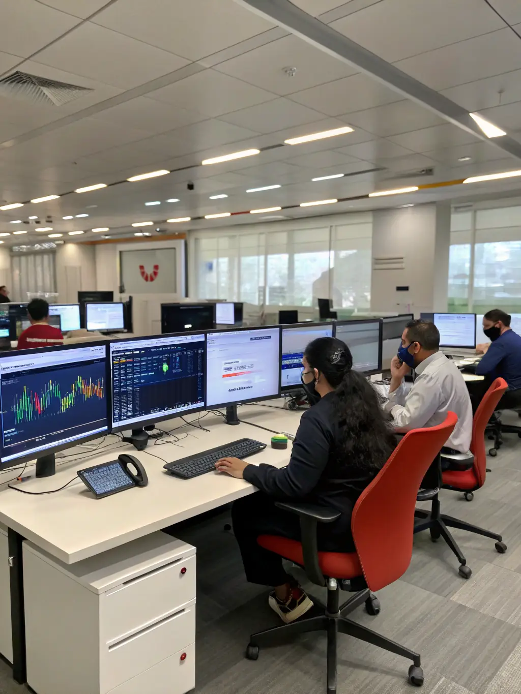 A professional office setting with employees efficiently using mobile devices and desk phones, showcasing the flexibility of a hybrid IP system.