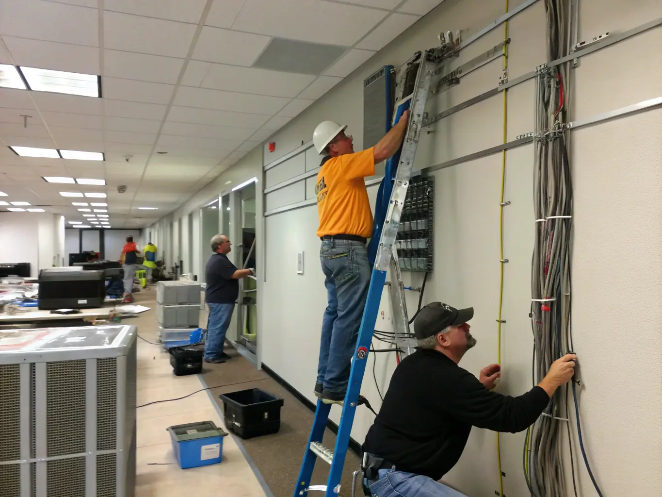 A team of DataTel 360 technicians is carefully moving and reinstalling a legacy Nortel phone system in a new office location, ensuring proper setup and functionality.