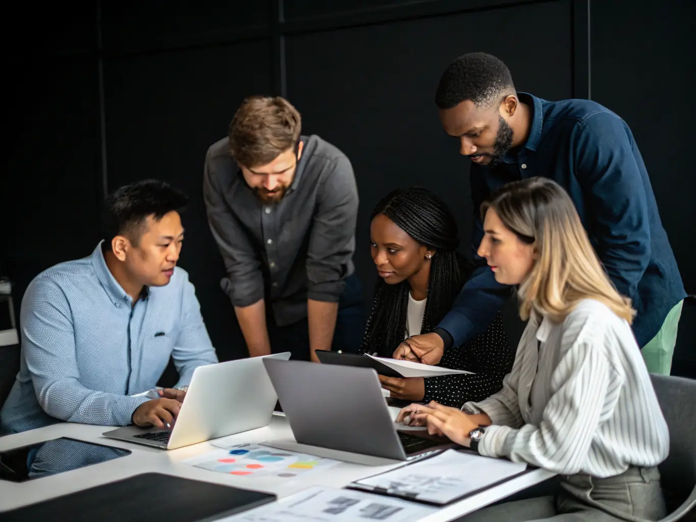 A diverse team of IT professionals collaborating in a modern office environment, working on enterprise-level network infrastructure. The image should convey experience and expertise in handling complex IT projects.